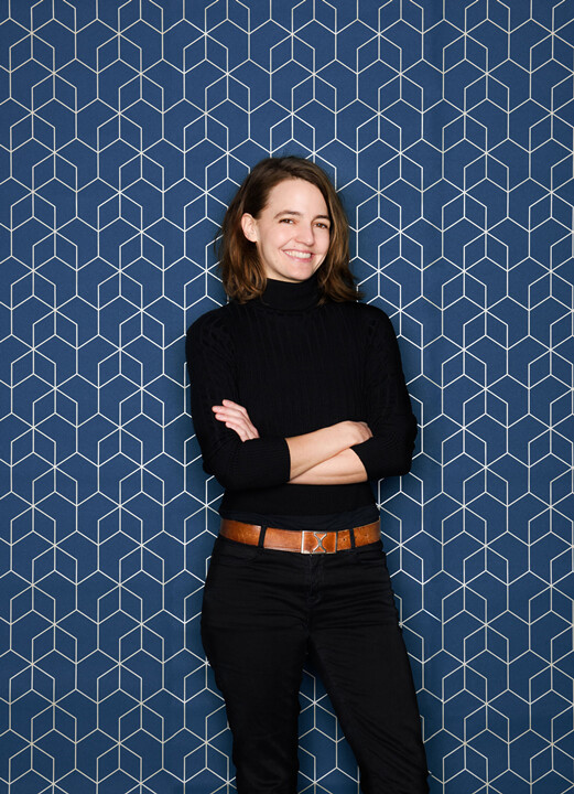 Katharina Breier vor einer Tapete mit geometrischem Muster