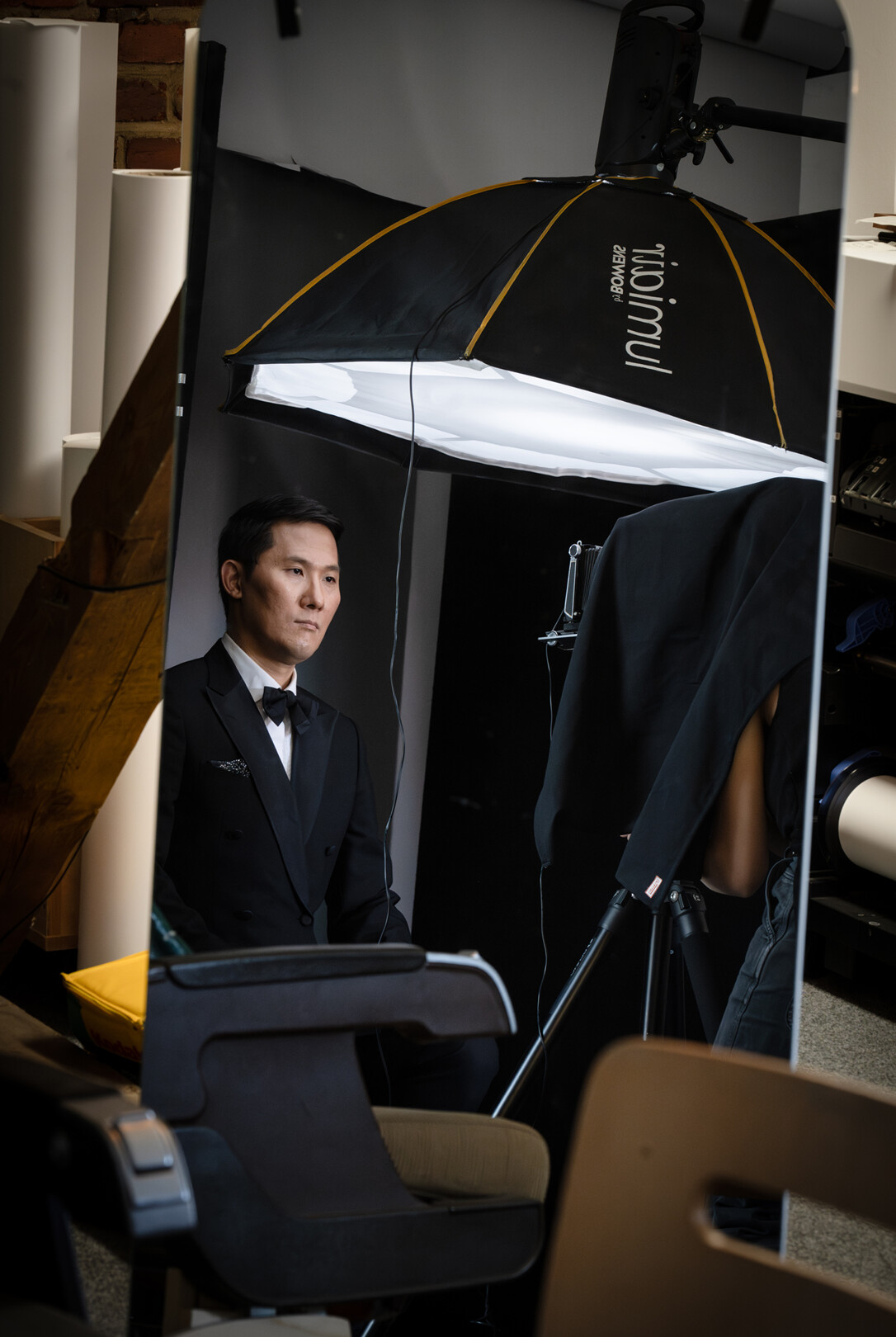 Sung Min Song steht vor der Kamera in einem Anzug und wartet, dass die Polaroidkamera auslöst.